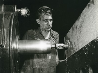 Просверливание отверстия в крупном блоке гидравлического клапана, который будет частью гидравлического пресса на пороховой фабрике. Январь 1942 года. Из архива промышленной компании «Вогт» (Vogt), архив Луисвилльского университета.