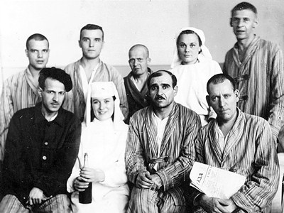 Nurses Sitnikova V.N. (standing in the 2nd row) and Pechenkina with a group of the wounded in Evacuation Hospital No. 1017, 1943. The State Archive of Perm Krai.