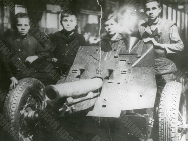Young workers of the V.M. Molotov Plant No. 172 near the 76-mm regimental gun ОБ-25 assembled with their help