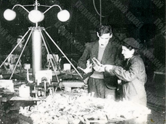 Начальник литейного цеха Молотовского завода №33 Б.В. Коноплев (второй справа) проверяет качество отливок у одной из работниц цеха