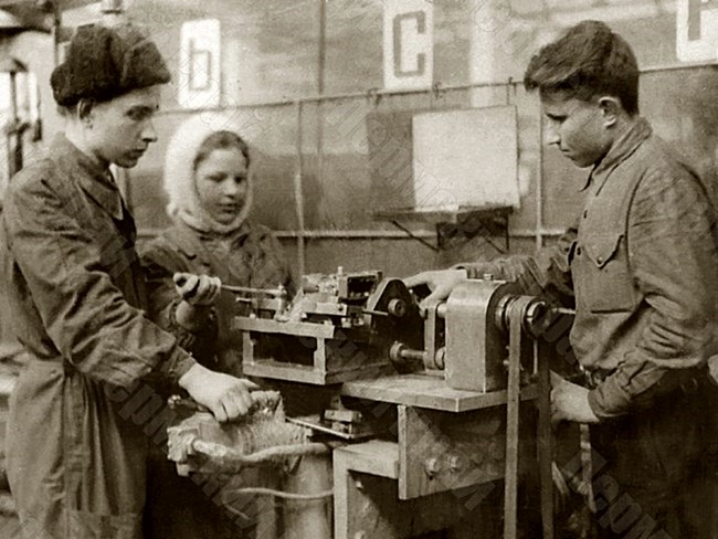 Мастер Молотовского завода №33 П.П. Зубарев (первый слева) обучает молодых рабочих завода работе на станке