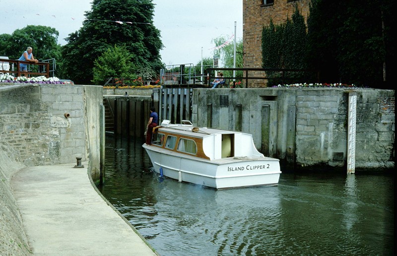 A River Thames hire boat entering Sandford Lock from downstream